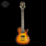 A Prichard electric guitar with a vibrant orange and brown flame maple finish, shown against a solid black background. The brand logo on the headstock is visible but small, and a 'TONE SHOP' watermark is in the top-left corner.