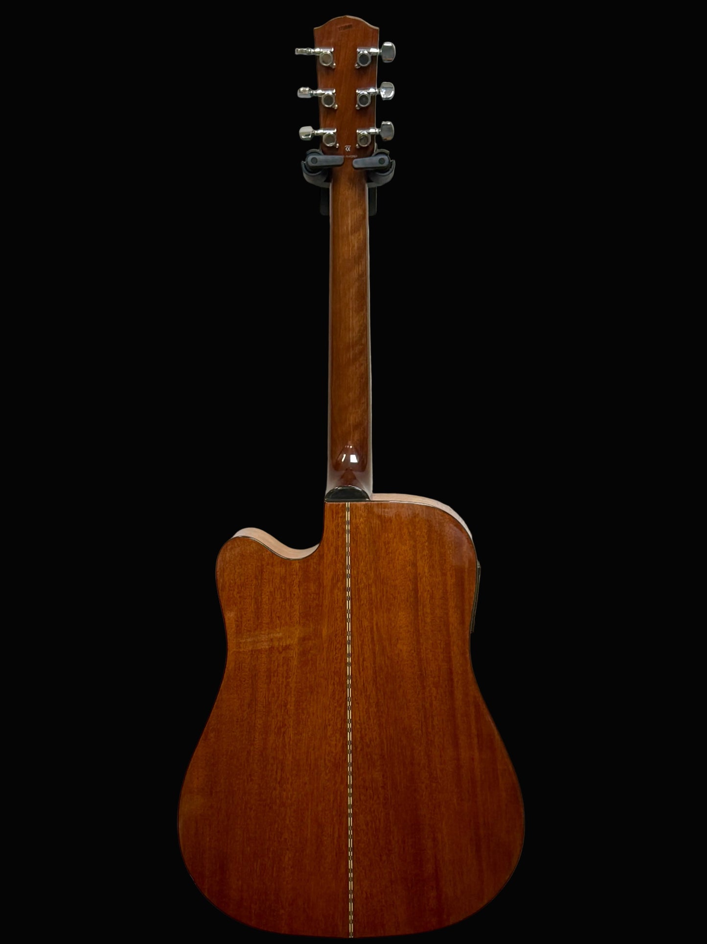 Back view of a wooden acoustic guitar on a light gray background
