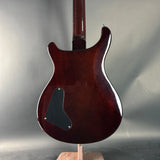 Guitar body on a stand against a gray background