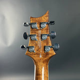 Guitar headstock with PRS tuning pegs on a gray background