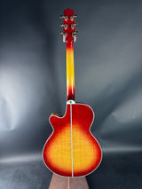 Acoustic guitar with a sunburst finish on a reflective gray surface