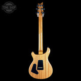 A natural wood electric guitar shown from the back against a solid black background, with a Tone Shop watermark in the top-left corner.