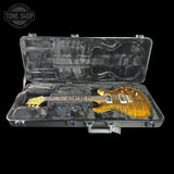 An electric guitar with a gold flame finish is displayed inside an open black hard case with a custom foam insert. The brand logo 'TONE SHOP' is visible in the top left corner.