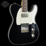 A black electric guitar with a white pickguard and chrome hardware, shown against a solid black background with a Tone Shop watermark in the top-left corner.