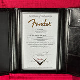 A Fender Certificate of Authenticity insert displayed inside a black leather portfolio folder with a red velvet interior.