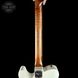 Close-up of the back of an electric guitar showing a glossy white body, a maple neck with prominent natural wood grain, and a black Tune Shop branded tailpiece, set against a solid black background.