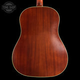 Back view of a wooden acoustic guitar with 'Tone Shop' logo in the corner.
