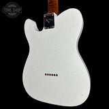The back of a white Fender Telecaster electric guitar body, featuring a black plate with a signature decal, six control screws, and a dark wood neck visible at the top, set against a solid black background.