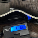 A close-up of a guitar body resting on a smart weigh electronic scale, showing the scale's blue digital display reading 9.85 kg.