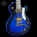 Blue electric guitar with gold hardware on a black background, featuring 'Tone Shop' logo.