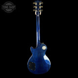 Blue electric guitar on a black background with 'Tone Shop' logo.