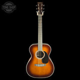 A classic acoustic guitar with a sunburst finish, shown from the front against a solid black background. The brand 'Gibson' is visible on the headstock.