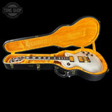 Electric guitar in an open case with 'Tone Shop' branding.