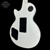 White electric guitar with black pickguard on a black background, featuring 'Tone Shop' logo.