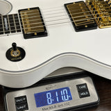 White electric guitar on a digital scale displaying weight