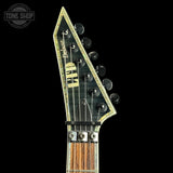 Close-up of a guitar headstock with 'Deluxe' branding on a black background