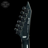 Close-up of a guitar headstock with ESP branding on a black background