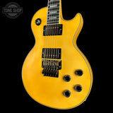 Yellow electric guitar on a black background with 'Tone Shop' logo.
