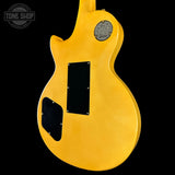 Yellow electric guitar body with Gibson logo on a black background