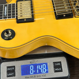 Yellow electric guitar on a digital scale displaying weight