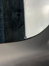 Close-up of a metallic surface with hair strands and a blue fabric background