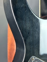 Close-up of a guitar's headstock with visible wear and tear.