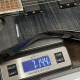 Digital scale displaying weight of a guitar on a wooden surface