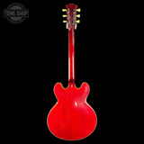 Red electric guitar on a black background with 'Tone Shop' logo.