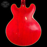 Red electric guitar body with a visible brand logo in the corner.
