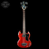 Red electric bass guitar on a black background with 'Tone Shop' logo.