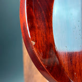 Close-up of a wooden object with a glass component on a gray background