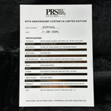 A white printed specification card for a PRS Custom 24 Limited Edition guitar, laid flat on a black textured background. The card includes the PRS logo, serial number, date, and detailed specifications for the custom maple curved top, black gloss mahogany neck, rose wood back, and gold hardware.