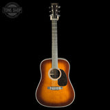 A vintage-style acoustic guitar with a sunburst finish, shown vertically against a solid black background. The brand 'Martin' is visible on the headstock.