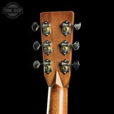 Close-up of a guitar headstock with tuning pegs on a black background, featuring the Tone Shop logo.