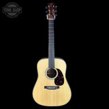 Acoustic guitar with a visible brand logo on a black background