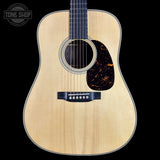 Acoustic guitar with a visible brand logo on a black background