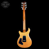 A classic electric guitar with a natural wood finish, shown from the back against a solid black background. The brand 'Tone Shop' is visible as a watermark in the top-left corner.