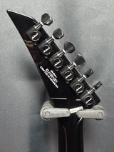 Close-up of a guitar's tuning pegs on a gray background