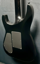 Close-up of a black electric guitar with silver pickguard on a gray background