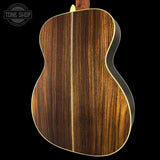 Close-up of a guitar's wooden back with 'Tone Shop' logo.