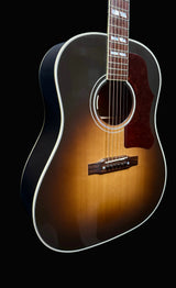 Acoustic guitar with a sunburst finish against a dark blue background