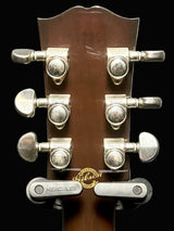 Guitar headstock with tuning pegs on a gray background