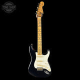 Black electric guitar with a white pickguard on a black background, featuring the Tone Shop logo.