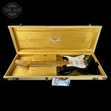 Gold electric guitar in a case with Fender logo, Tone Shop branding.