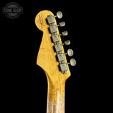Close-up of a guitar headstock with tuning pegs on a black background, featuring the Tone Shop logo.