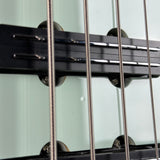 Close-up of a guitar's bridge and strings with a neutral background