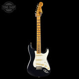 Electric guitar with a black body and white pickguard on a black background, featuring 'Tone Shop' branding.