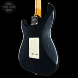 Black electric guitar with a visible brand logo on a black background