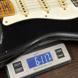 Digital scale displaying weight of a guitar on a wooden surface