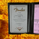 Fender certificate of authenticity in a black frame on a yellow textured background
